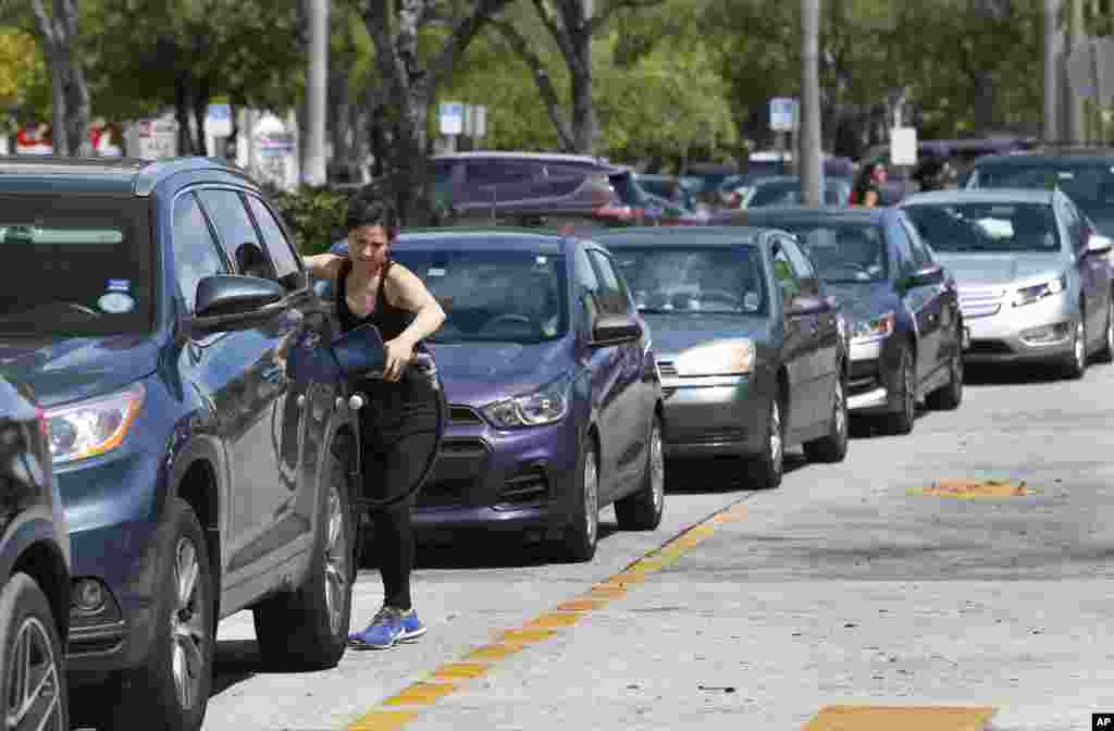 Una mujer pone gasolina en su auto en una estación de gasolina del Club mayorista Costco en North Miami, Florida, mientras el huracán Irma avanza por el Caribe con fuerza récord abatiéndose sobre casas e inundando edificios en una cadena de islas de las Antillas Menores de camino hacia Puerto Rico, la República Dominicana, Haití, Cuba y posiblemente Florida. AP Sept. 6, 2017.