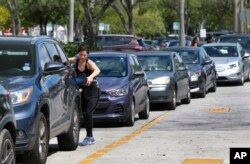 FILE - Anticipating Hurricane Irma's arrival, a customer pumps gas at a Costco gas station in North Miami, Florida, Sept. 6, 2017.