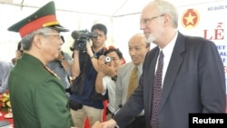 越南和美國官員在峴港啟動清除橙劑項目儀式上握手