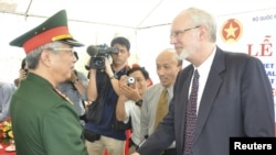 Виетнамскиот заменик-министер за одбрана Нгуен Чи Вин и американскиот амбасадор Дејвид Шиар се ракуваат на почетокот на проектот за деконтаминација на поранешната американска база во Дананг, Виетнам