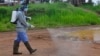 Ebola health workers spray disinfectant on a road near the home of a 17-year old boy that died from the Ebola virus on the outskirts of Monrovia, Liberia, Wednesday, July 1, 2015.