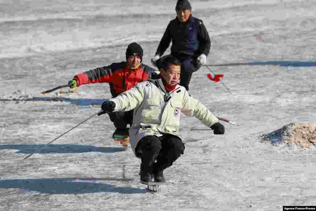 Warga bermain seluncur di sebuah danau yang membeku di kota Shenyang, provinsi Liaoning timur laut China. (Foto: AFP)