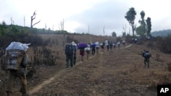In this Jan. 8, 2010 picture released by the Free Burma Rangers, Karen villagers carrying relief supplies walk on a path as they flee Burmese soldiers in Karen State.