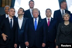 From left, NATO Secretary General Jens Stoltenberg, Greek Prime Minister Alexis Tsipras, U.S. President Donald Trump, Hungarian Prime Minister Voktor Orban and Britain's Prime Minister Theresa May pose for a family photo during a NATO summit at their new