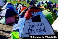 FILE - A tent bears an appeal for aid to migrants encamped in Idomeni, Greece, near the border with Macedonia, March 4, 2016.