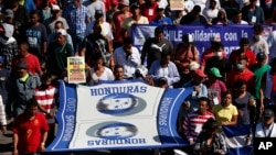 A group of Central American migrants, representing the thousands participating in a caravan trying to reach the U.S. border, undertake an hours-long march to the UN's humans rights office in Mexico City, Nov. 8, 2018. 