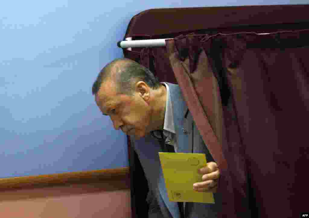 Turkey's Prime Minister Tayyip Erdogan gets ready to cast his vote at a polling station in Istanbul June 12, 2011. Turks began voting in an election on Sunday that is expected to return Prime Minister Tayyip Erdogan to office for a third consecutive term