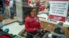 Zandile Mlotshwa, 21 ans, caissière au supermarché Spar dans la banlieue de Norwood à Johannesburg, compte son argent à la fin de sa journée de travail le 30 mars 2020. (AP Photo/Jerome Delay)
