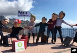 Oxfam activists wearing masks of the leaders of the G-7 summit (from left) Italian Premier Paolo Gentiloni, US President Donald Trump, German Chancellor Angela Merkel, Japanese Prime Minister Shinzo Abe, French President Emmanuel Macron and Canadian Prime