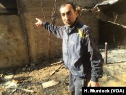 Wissam Rashid points to what looks like oil residue after his home, now condemned, was bombed, spraying a foul-smelling oily substance on his home and garden in eastern Mosul, Iraq, March 8, 2017.