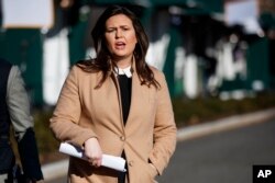 FILE - White House press secretary Sarah Sanders talks with reporters outside the White House, Dec. 18, 2018.
