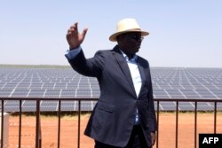 FILE - Senegal President Macky Sall poses in front of solar panels on Oct. 22, 2016 during the opening ceremony of a new photovoltaic energy production site in Bokhol.