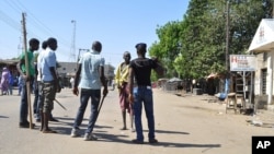 Vigilante barricade a road after two explosions occurred at a market in Maiduguri, Nigeria, Dec. 1, 2014.