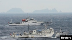 An aerial photo shows Chinese marine surveillance ships Haijian No. 49 (front) and Haijian No.50 cruising in the East China Sea, as the islands known as Senkaku isles in Japan and Diaoyu islands, April 23, 2013.