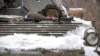 2022年1月28日，在乌克兰东部卢甘斯克地区的前线阵地附近，一名乌克兰军人从装甲运兵车上向外凝视。（美联社）