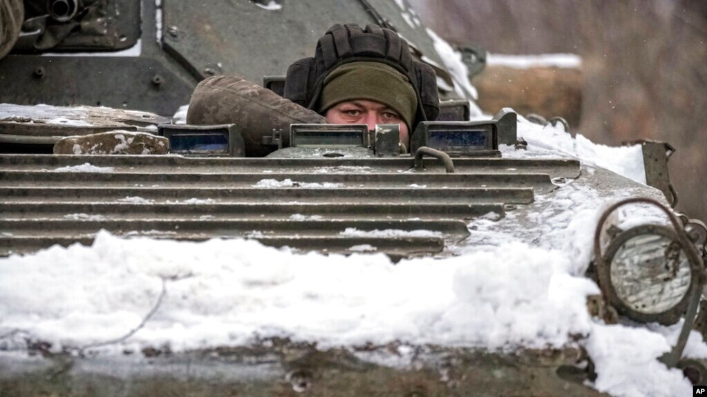2022年1月28日，在乌克兰东部卢甘斯克地区的前线阵地附近，一名乌克兰军人从装甲运兵车上向外凝视。（美联社）(photo:VOA)