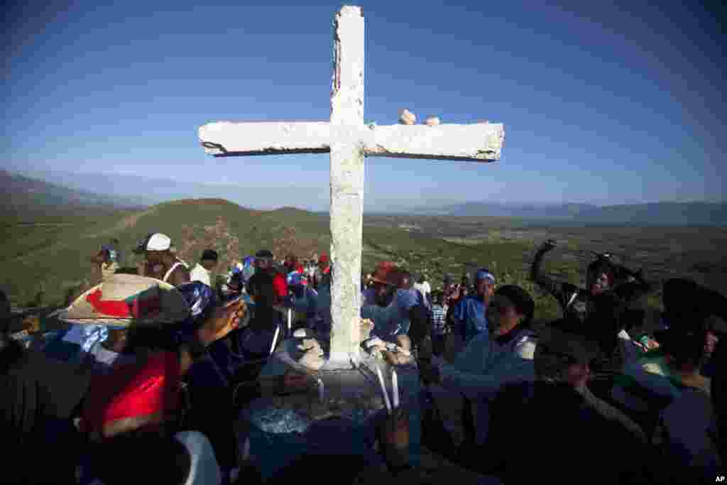 Pilgrims kneel in prayer after reaching the final of the 14 Stations of the Cross, symbolizing when Jesus Christ was laid in his tomb, on Morne Calvaire Miracle, in Ganthier, Haiti, April 3, 2015.