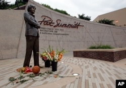 Flowers lay alongside a basketball fans have left at the Pat Summitt statue in Knoxville, Tennessee, June 28, 2016.