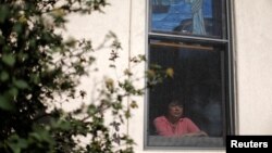 Immigrant Rosa Sabido, who lives in sanctuary in the United Methodist Church while facing deportation, looks out from a church window in Mancos, Colorado, July 19, 2017. 