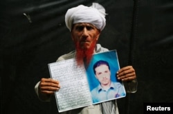 Shodeen Khan 77, holds a photo of his son, Mustaqeem Khan, a former student of the Islamia College Peshawar who has been missing for nine years, is seen at a human rights rally by the Pashtun Tahaffuz Movement (PTM), in Karachi, Pakistan, May 13, 2018.