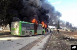 حلب سے شہریوں کو لے جانے والی ایک بس پر حملے کے بعد آگ لگی ہوئی ہے