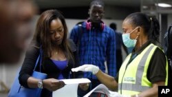 Petugas kesehatan Nigeria memberikan penjelasan kepada penumpang di bandara Lagos, Nigeria, Rabu (6/8). 