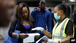 A Nigerian port health official speaks to a passenger arriving at Murtala Muhammed International Airport in Lagos, Nigeria, Aug. 6, 2014.