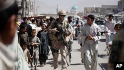 Canadian soldiers of Task Force Kandahar walk with locals down a street as they conduct a foot patrol in Kandahar city (File)