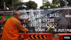 Seorang Banthe menaruh bunga untuk para ABK KRI Nanggala 402 yang gugur (foto Petrus Riski/VOA)