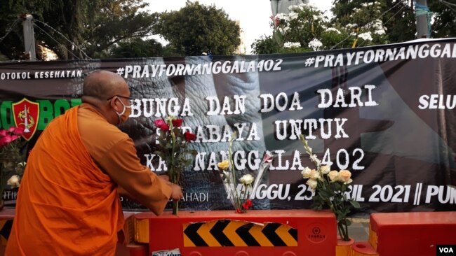 Seorang Banthe menaruh bunga untuk para ABK KRI Nanggala 402 yang gugur (foto Petrus Riski/VOA)