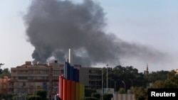 Black smoke billows in the sky above areas where clashes are taking place between pro-government forces and an alliance of former anti-Moammar Gaddafi rebels, in Benghazi, Nov. 26, 2014. 