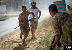 Fighters loyal to the internationally recognized Government of National Accord (GNA) run for cover during clashes with forces loyal to strongman Khalifa Haftar south of the capital Tripoli's suburb of Ain Zara, on April 25, 2019.