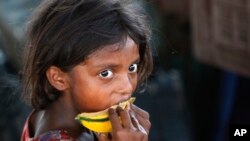 A child laborer eats a piece of a muskmelon near Jammu, India, June 12, 2015.