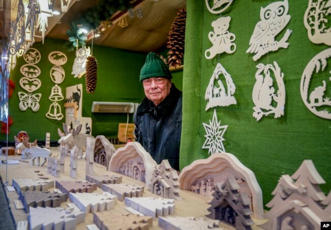 Vender Nils Knauerbstnads stands in his booth at the Christmas market in central Frankfurt, Germany, Nov. 23, 2021.