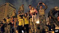 Egyptian Army soldiers celebrate with children on their armored personnel carrier, as they celebrate the news of the resignation of President Hosni Mubarak, Feb. 11, 2011