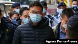 Pemimpin redaksi Stand News Patrick Lam dibawa menuju kantor media tersebut dengan tangan terborgol setelah polisi menggerebek media tersebut pada 29 Desember 2021. (Foto: AFP/Daniel Suen)