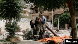 FILE - Members of the Islamist rebel group Jabhat al-Nusra prepare a homemade mortar in the Bustan al-Qasr neighborhood of Aleppo, Syria, June 5, 2014.