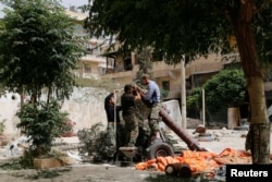 FILE - Members of the Islamist rebel group al-Nusra Front prepare a homemade mortar in the Bustan al-Qasr neighborhood of Aleppo, Syria, June 5, 2014.