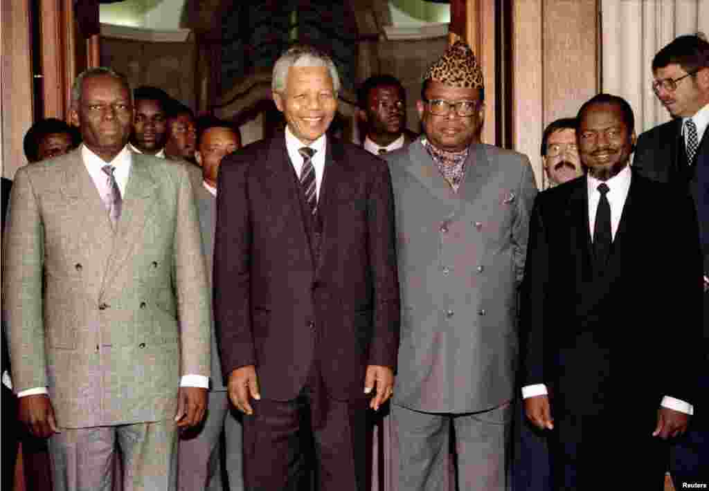 Presidente de Angola, Eduardo dos Santos (esquerda); então presidente da África do Sul Nelson Mandela (segundo à esquerda); então presidente do Zaire, Mobutu Sese Seko (ao lado direito de Mandela); e o então presidente de Moçambique Joaquim Chissano (direita), em 1994, em negociações para a paz em Angola.