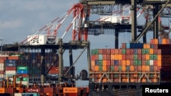 Un barco caragado de contenedores de envío se descarga en un muelle en Port Newark, Nueva Jersey, EE. UU., 19 de noviembre de 2021.