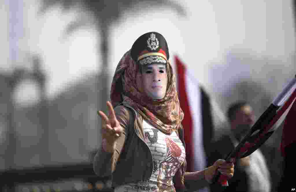 An Egyptian woman wears a mask of Egypt&#39;s Defense Minister Gen. Abdel-Fattah el-Sissi in Tahrir Square, in Cairo, Egypt.