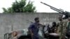 Forças leais a Ouatara com um homem morto numa rua de Abidjan