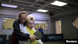 Holocaust survivor Betty Stein, 92, (R) is helped by coach Irina Jestkova as she plays ping pong at a program for people with Alzheimer's and dementia at the Arthur Gilbert Table Tennis Center in Los Angeles, California. (June 2011)