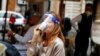 Seorang pelanggan perempuan yang mengenakan pelindung wajah, meminum kopi di sebuah kafe di Roma saat Italia mulai mengendorkan karantina Covid-19. 