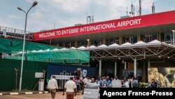 Les passagers arrivant sur des vols internationaux quittent le hall des arrivées internationales à l'aéroport d'Entebbe en Ouganda, le 3 mars 2020.