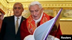 Pope Benedict XVI exchanges gifts with Guatemala's President Otto Perez Molina during a private audience at the Vatican February 16, 2013.