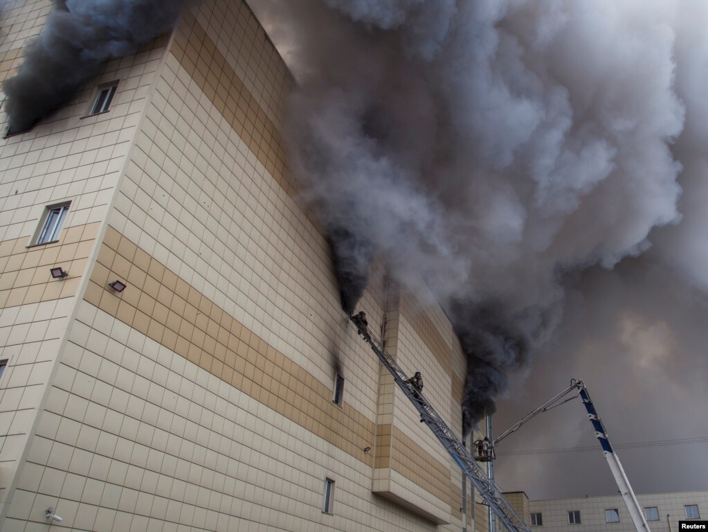 러시아 시베리아의 케메로보시 중심부에 있는 4층 쇼핑몰에서 화재가 발생해 소방관들이 진압하고 있다.