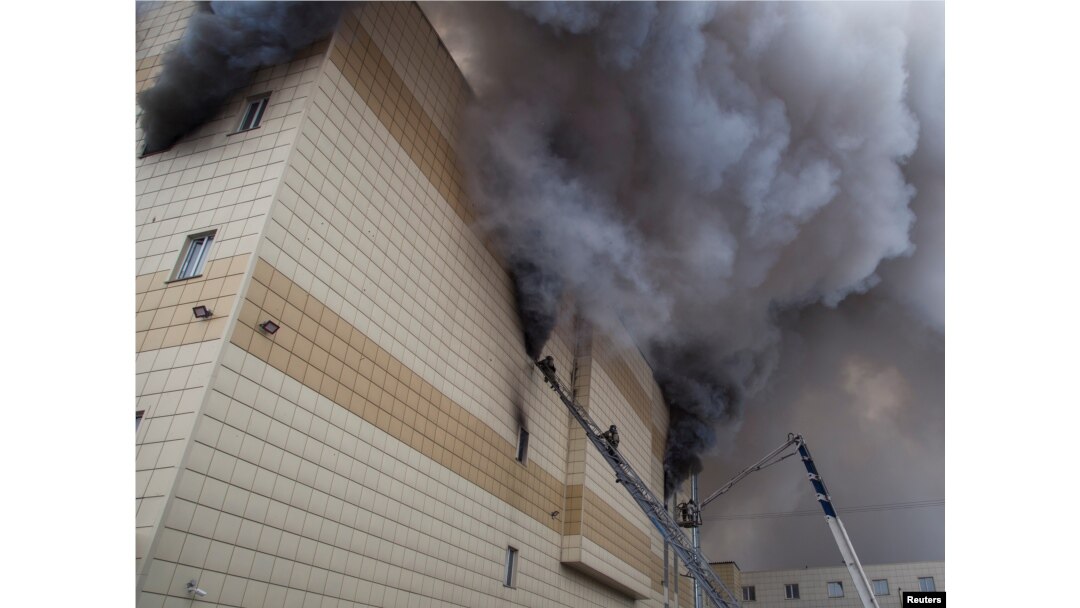 Members of the Emergency Situations Ministry work to extinguish a fire in a shopping mall in the Siberian city of Kemerovo, Russia.