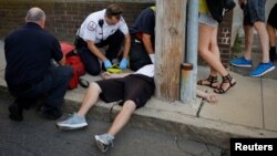 Petugas paramedik Cataldo Ambulance dan petugas gawat darurat lainnya berusaha menyelamatkan pria berusia 32 tahun yang ditemukan tak sadarkan diri dan tak bernapas akibat overdosis obat pengurang nyeri, opioid, di trotoar di Everett, Boston, Massachusetts, 23 Agustus 2017. 