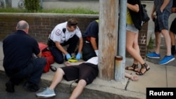 FILE - Cataldo Ambulance medics and other first responders revive a 32-year-old man who was found unresponsive and not breathing after an opioid overdose on a sidewalk in the Boston suburb of Everett, Massachusetts, Aug. 23, 2017. 